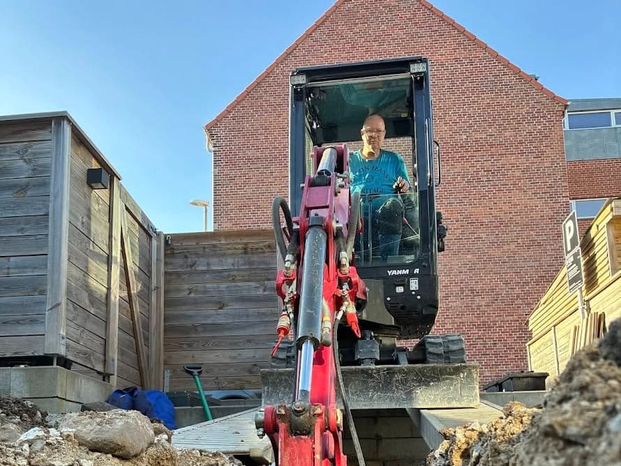 Yanmar minigraver i arbejde i en smal baggård